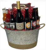 In a metal container wrapped in twine, three bottles of beer, three bottles of soda and one bottle of wine all from the northwest along with local snacks.