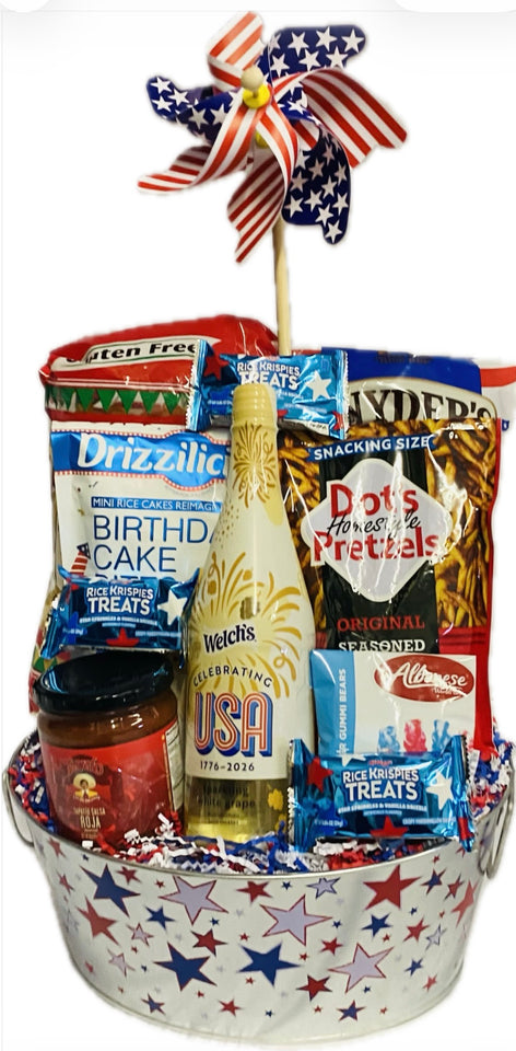 Gift basket with snacks and a bottle of sparkling white grape juice on a white background.