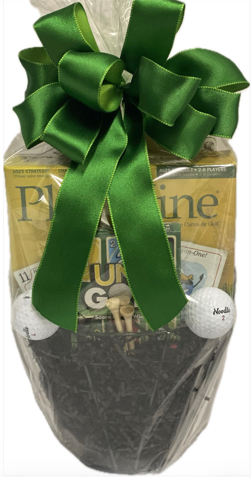 Golf-themed gift basket with green ribbon, golf balls, and golf card games on a white background