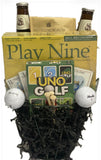 Golf-themed gift basket with 'Play Nine' and 'Uno Golf' cards, golf balls, and Conundrum game box.