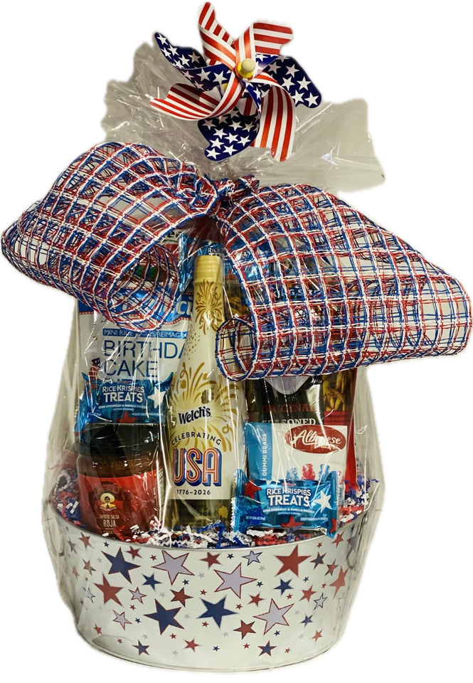 Gift basket with patriotic theme featuring sparkling white grape juice and snacks tied with a plaid ribbon.